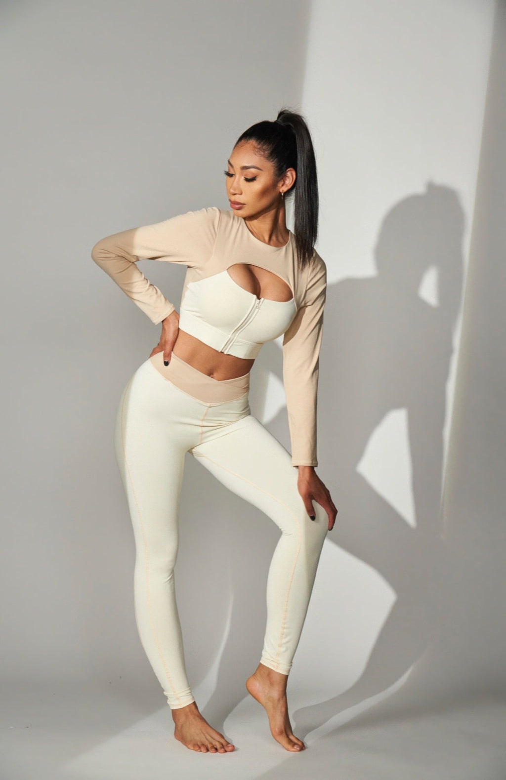 JULIETTA COLLECTION high-waisted color block leggings in cream and beige worn by a model in a studio setting.