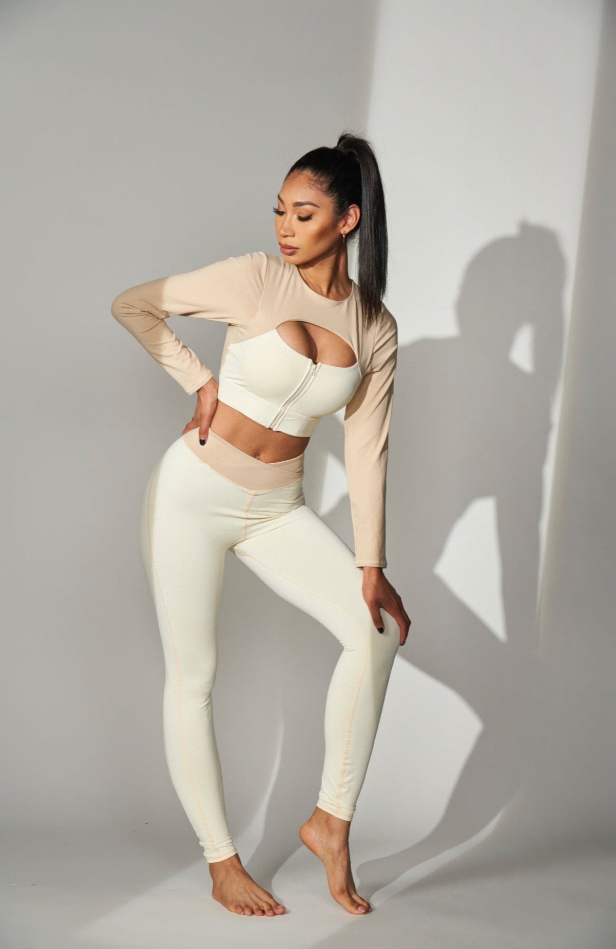 JULIETTA COLLECTION high-waisted color block leggings in cream and beige worn by a model in a studio setting.
